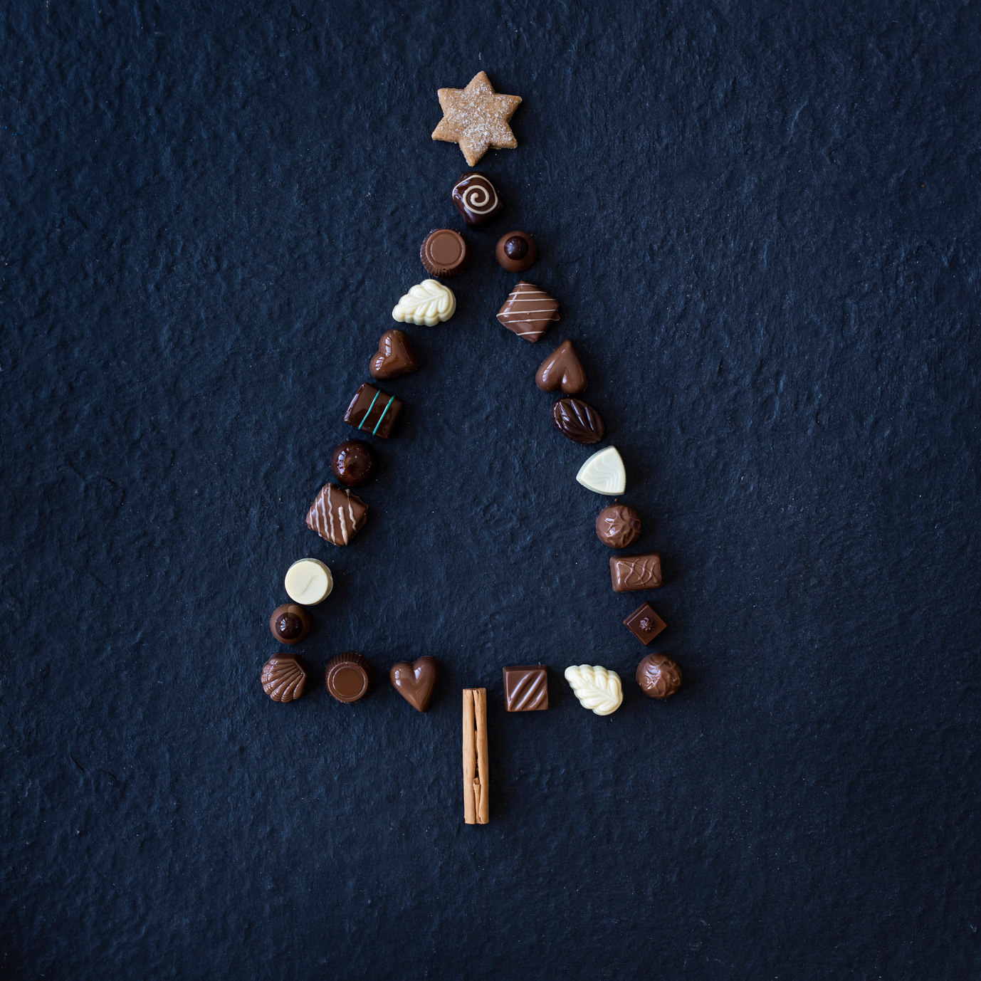 Forme de sapin de noël en bouchées de chocolat sur fond noir
