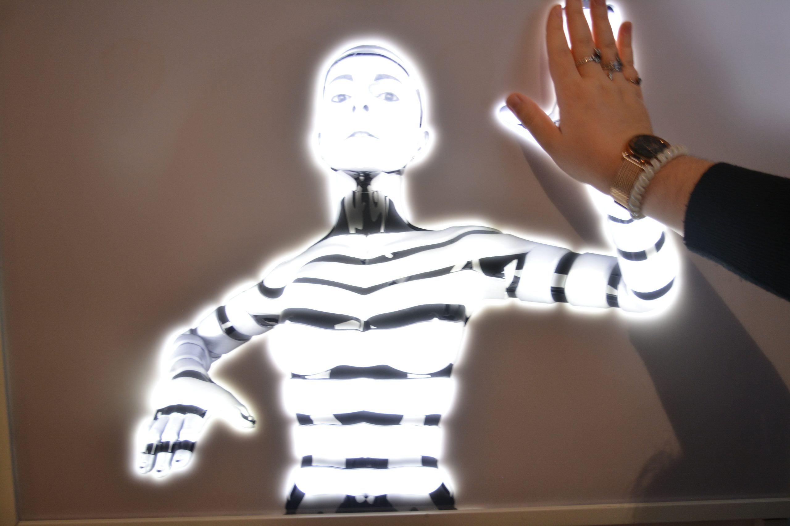 Lorsque l'on pose notre main d'humain sur sa main de cyborg, le robot s'illumine comme s'il prenait vie.