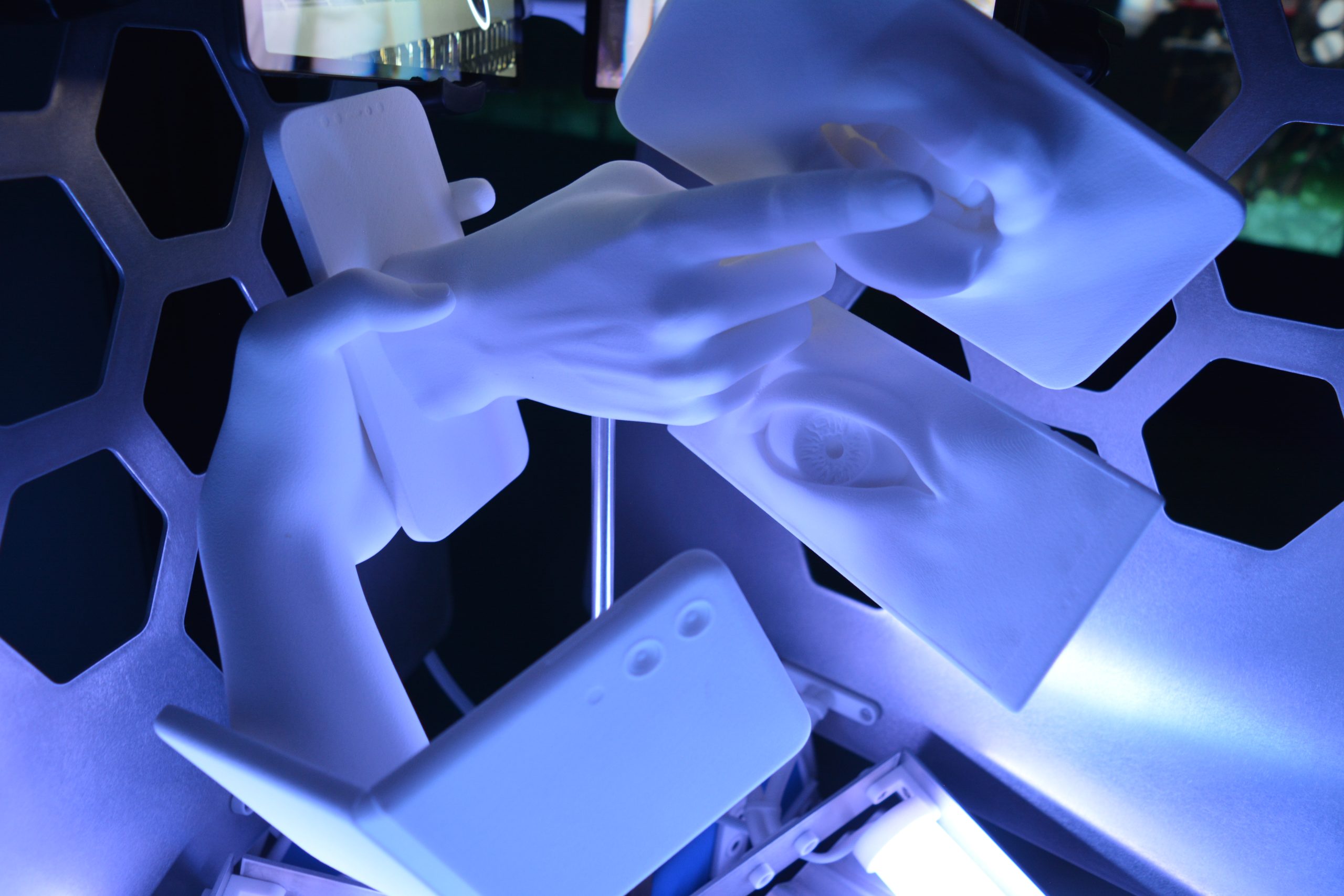 Sculpture représentant des téléphones portables avec une bouche, une main, un œil